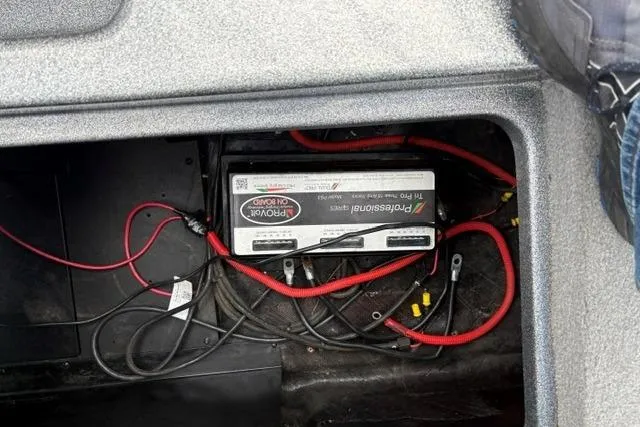 Slide: The Image of Battery compartment of a 2021 Caymas CX 19 boat with wiring visible. - 64