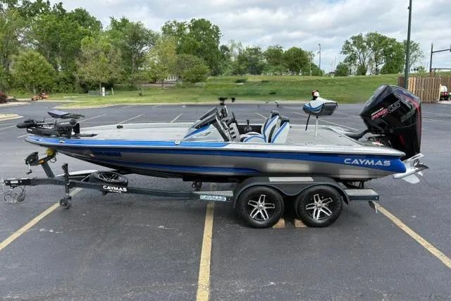 Slide: The Image of 2021 Caymas CX 19 boat on trailer in parking lot, blue and silver design. - 7