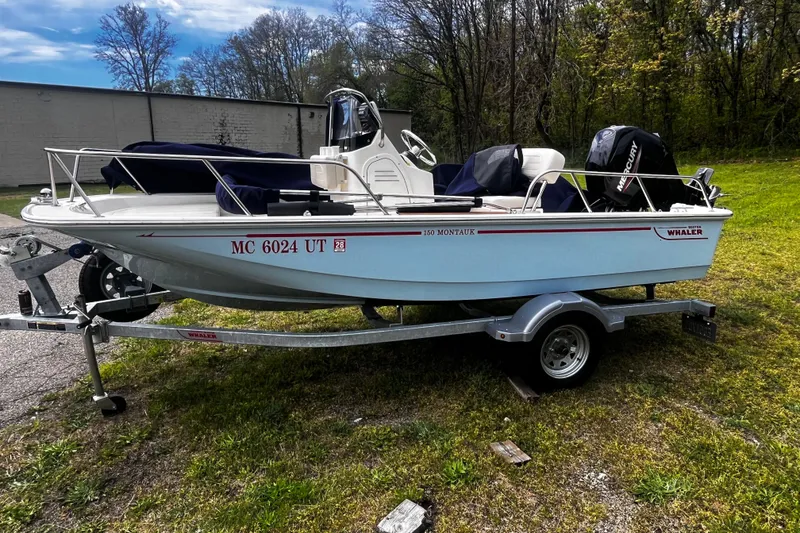 Slide: The Image of 2022 Boston Whaler 150 Montauk boat on trailer, parked outdoors. - 1