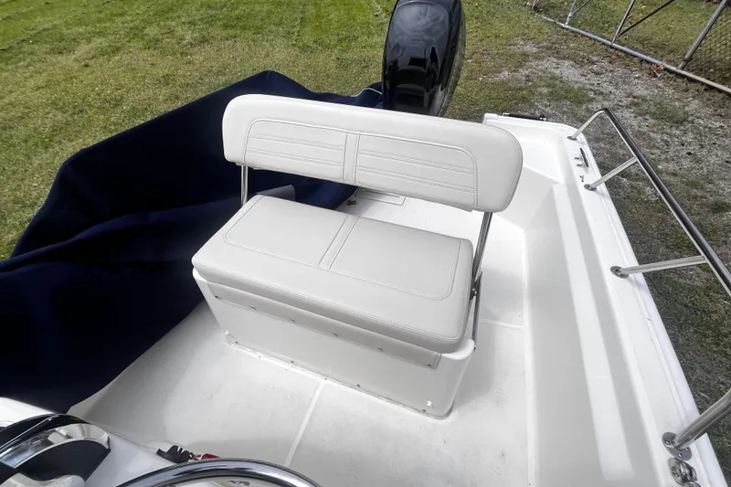 Slide: The Image of 2022 Boston Whaler 150 Montauk boat interior with white seating and railing. - 10