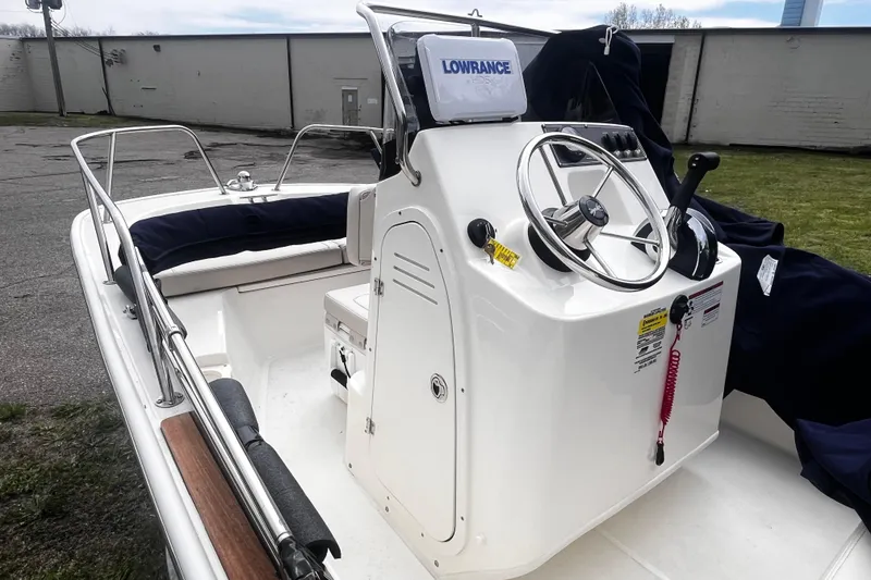 Slide: The Image of 2022 Boston Whaler 150 Montauk boat interior with steering console and navigation equipment. - 3