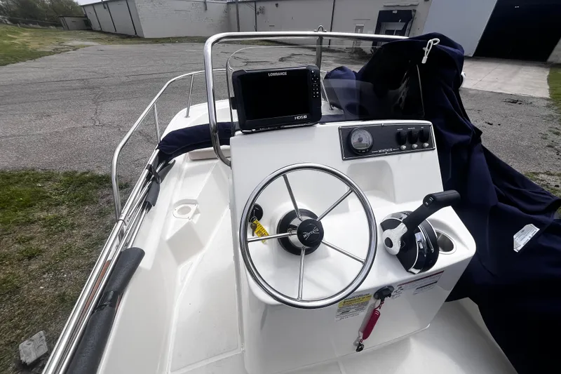 Slide: The Image of 2022 Boston Whaler 150 Montauk boat console with steering wheel and navigation equipment. - 4