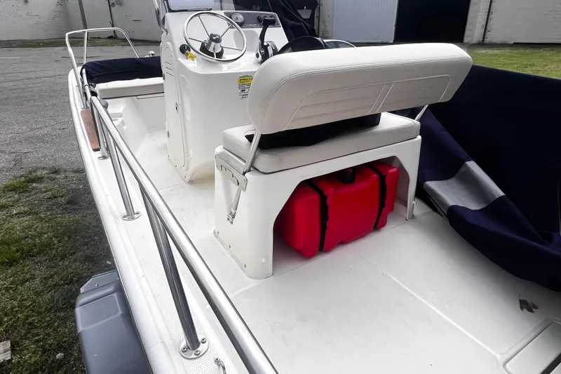 Slide: The Image of 2022 Boston Whaler 150 Montauk boat interior with steering console and seating. - 6
