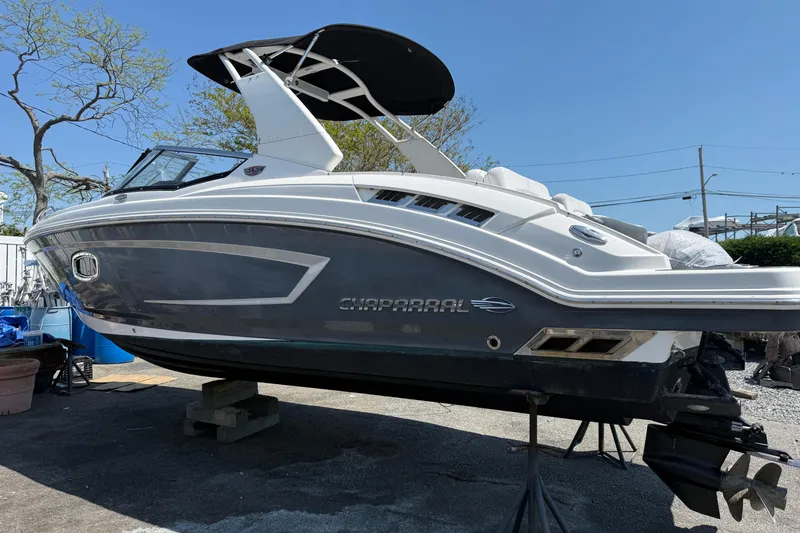 Slide: The Image of 2015 Chaparral 257 SSX boat with sleek design, docked outdoors under clear blue sky. - 13