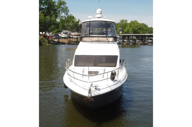 Slide: The Image of 2008 Sea Ray 36 Sedan Bridge yacht on calm water, surrounded by trees and docks. - 2