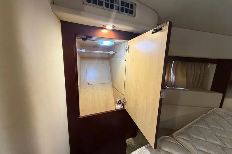 Slide: The Image of Interior cabin of 2008 Sea Ray 36 Sedan Bridge with open wooden cabinet. - 24