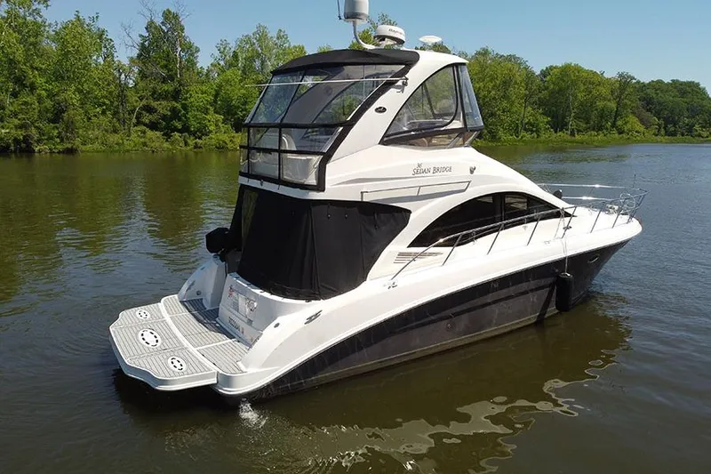 Slide: The Image of 2008 Sea Ray 36 Sedan Bridge yacht on a serene lake with lush greenery. - 3