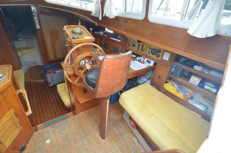 Slide: The Image of 1988 Gulf Pilot House interior with wooden helm, navigation instruments, and yellow seating. - 11