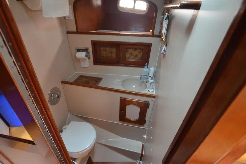 Slide: The Image of 1988 Gulf Pilot House bathroom with wooden accents, sink, and toilet. - 15