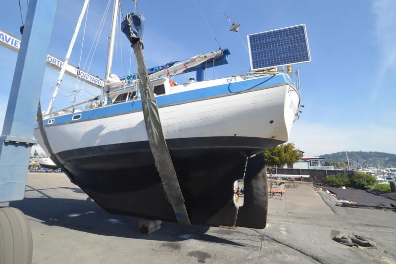 Slide: The Image of 1988 Gulf Pilot House sailboat in dry dock with solar panel, undergoing maintenance. - 18