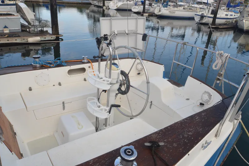 Slide: The Image of 1988 Gulf Pilot House boat cockpit with steering wheel, docked in marina. - 3