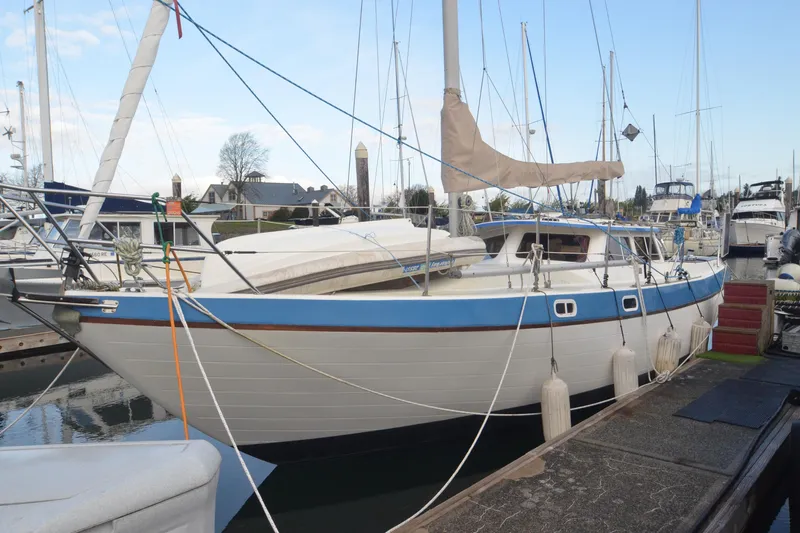 Slide: The Image of 1988 Gulf Pilot House sailboat docked at marina, featuring blue and white hull. - 4