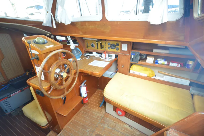 Slide: The Image of 1988 Gulf Pilot House interior with wooden helm, navigation equipment, and seating area. - 6