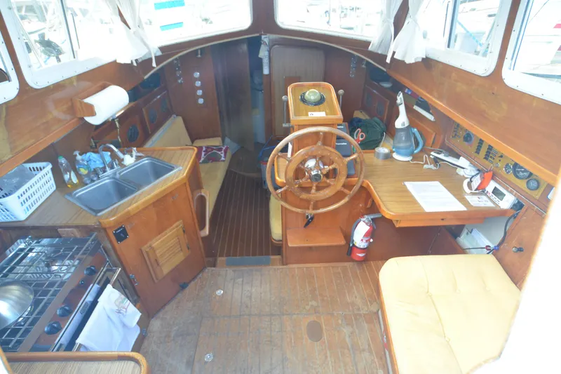 Slide: The Image of 1988 Gulf Pilot House interior with wooden helm, kitchen, and navigation area. - 7