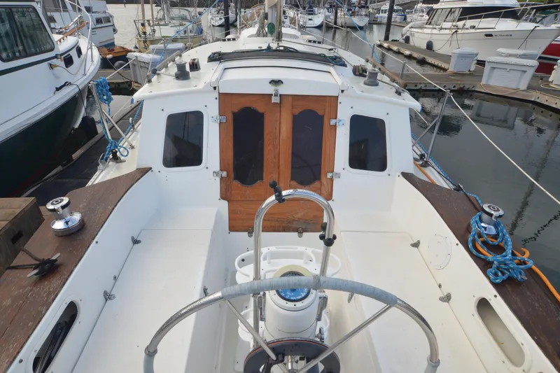 Slide: The Image of 1988 Gulf Pilot House sailboat cockpit with wooden doors, docked at marina. - 8
