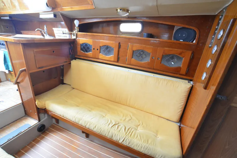 Slide: The Image of 1988 Gulf Pilot House interior with wooden cabinets and cushioned seating. - 9