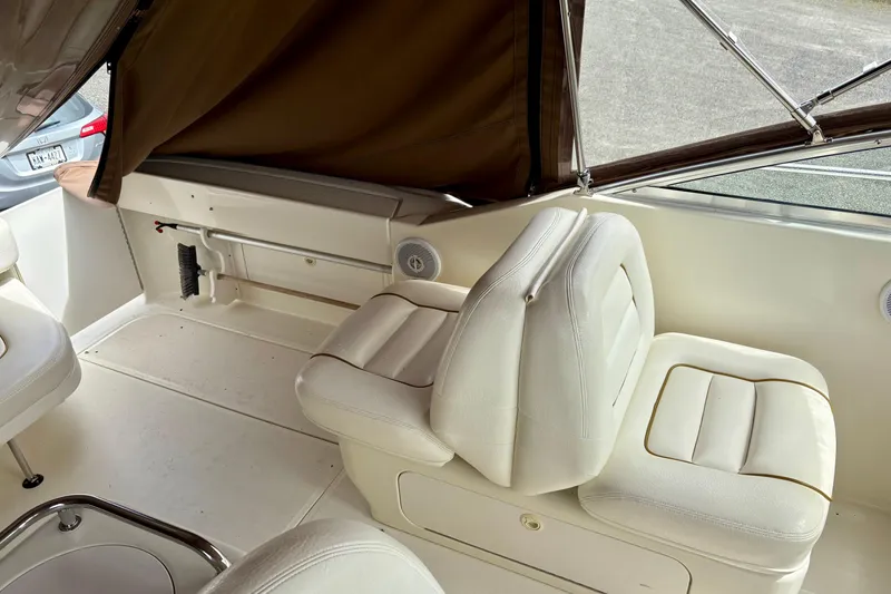 Slide: The Image of Interior of 2000 Sea Ray 290 Amberjack boat with white seating and brown canopy. - 10