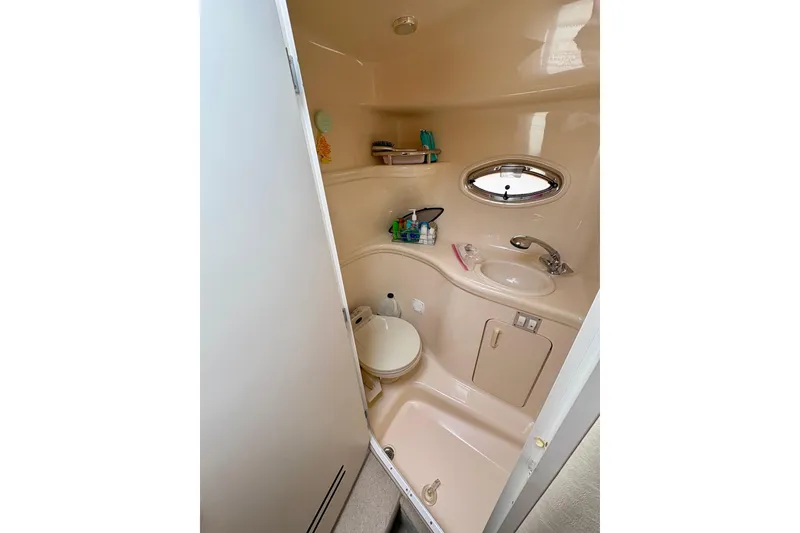 Slide: The Image of Compact bathroom in 2000 Sea Ray 290 Amberjack boat with sink, toilet, and porthole window. - 17