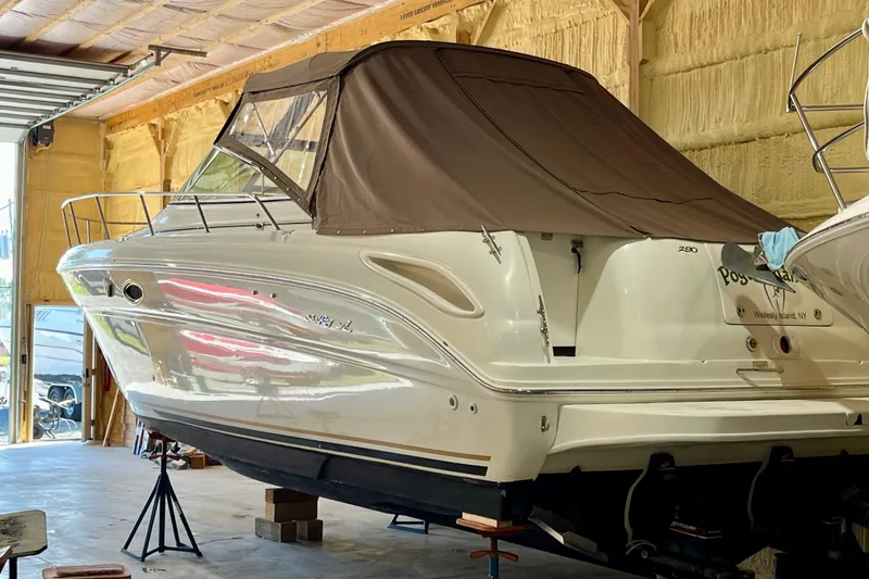 Slide: The Image of 2000 Sea Ray 290 Amberjack boat in storage, covered and elevated on stands. - 4