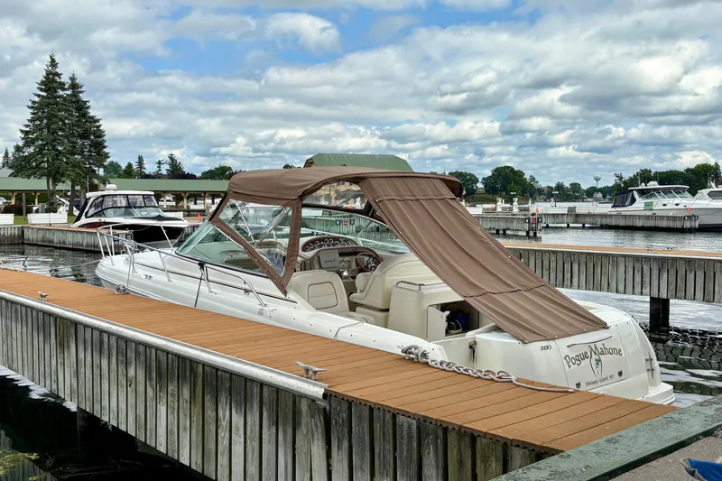 Slide: The Image of 2000 Sea Ray 290 Amberjack docked at a marina under a cloudy sky. - 6