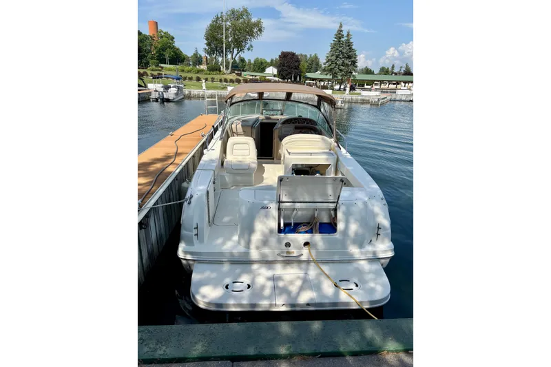 Slide: The Image of 2000 Sea Ray 290 Amberjack docked at a marina, showcasing its spacious deck and seating. - 7