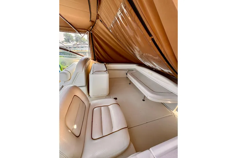 Slide: The Image of Interior view of 2000 Sea Ray 290 Amberjack boat with beige seating and canopy. - 8