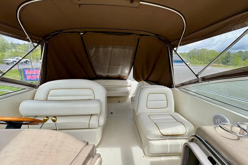 Slide: The Image of Interior of 2000 Sea Ray 290 Amberjack boat with white seating and brown canopy. - 9