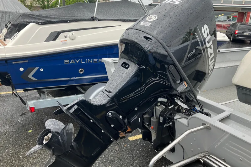 Slide: The Image of 2024 Smoker Craft Freedom 180 CC with Suzuki outboard motor in a parking lot. - 3