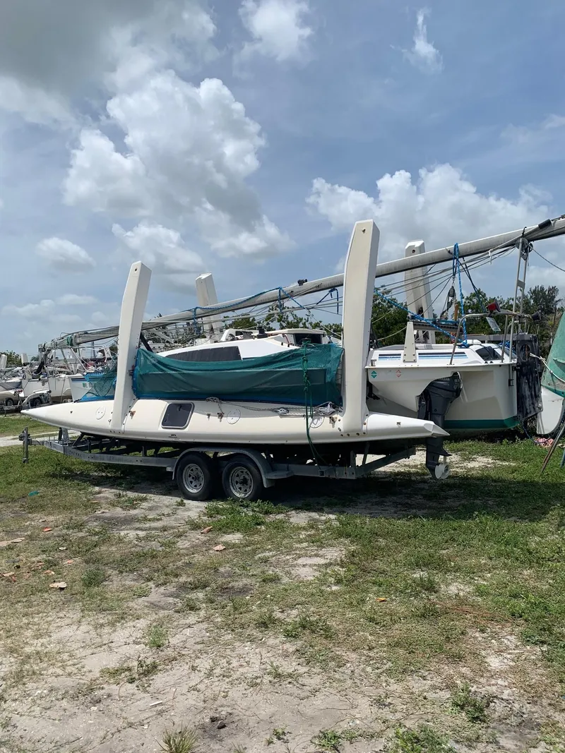 The Image of 1991 Corsair F27 trimaran on trailer under cloudy sky. - 1