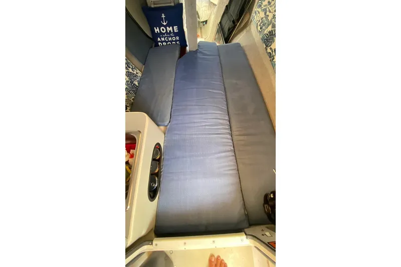 Slide: The Image of Interior of a 1991 Corsair F27 sailboat with blue cushions and nautical decor. - 13