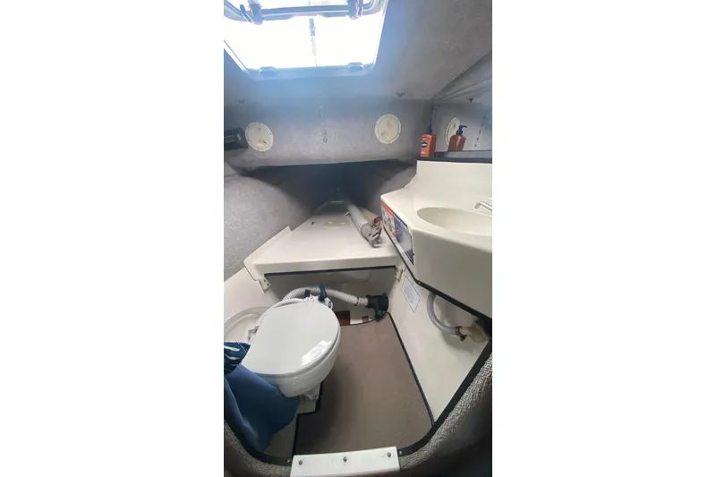 Slide: The Image of Interior of 1991 Corsair F27 boat featuring compact bathroom with toilet and sink. - 14
