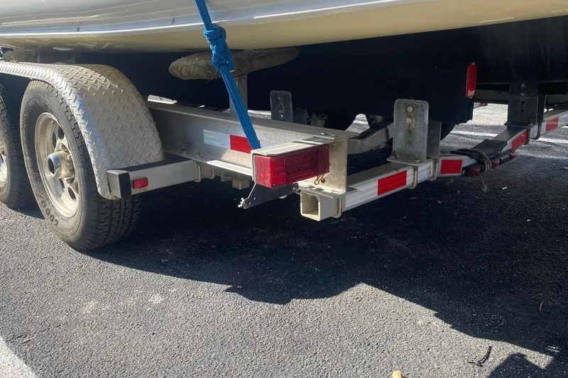 Slide: The Image of Trailer for 1991 Corsair F27 boat, featuring dual wheels and red reflectors. - 18