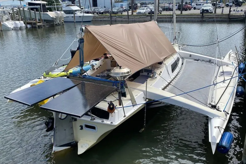 Slide: The Image of 1991 Corsair F27 trimaran with solar panels docked at a marina. - 8