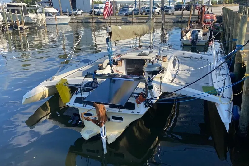 Slide: The Image of 1991 Corsair F27 trimaran docked at a marina, featuring a sleek design and American flag. - 9