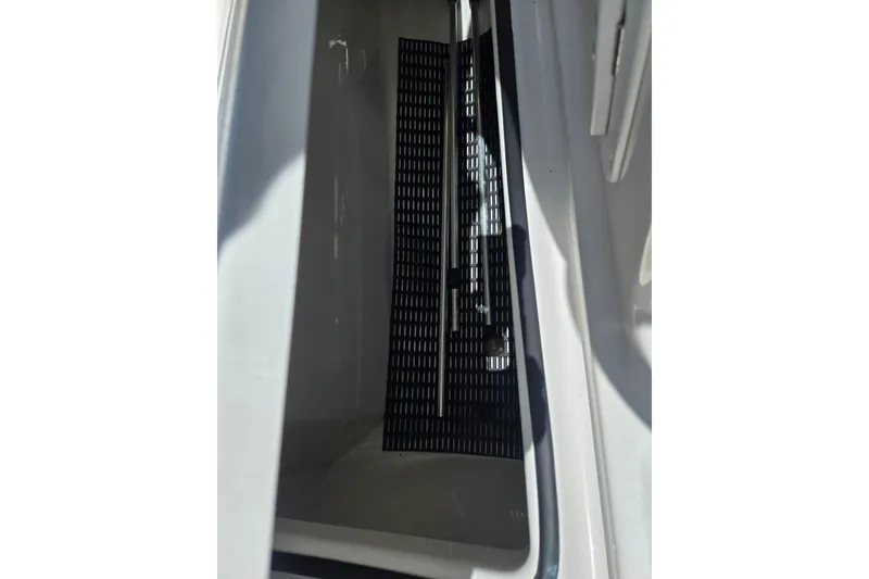 Slide: The Image of 2019 Yamaha Boats SX210 interior compartment with black mat and metal support. - 16