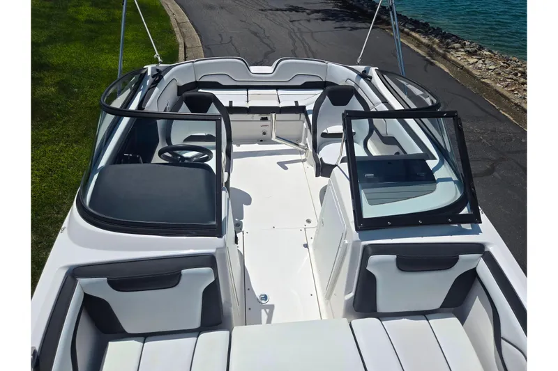 Slide: The Image of 2019 Yamaha Boats SX210 interior view, featuring sleek seating and modern design by the water. - 19