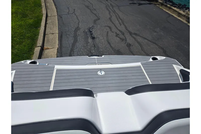 Slide: The Image of 2019 Yamaha Boats SX210 swim platform with gray decking, parked on asphalt road. - 23