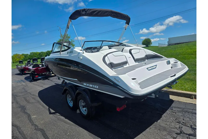 Slide: The Image of 2019 Yamaha Boats SX210 on trailer, sleek design, parked outdoors under blue sky. - 3