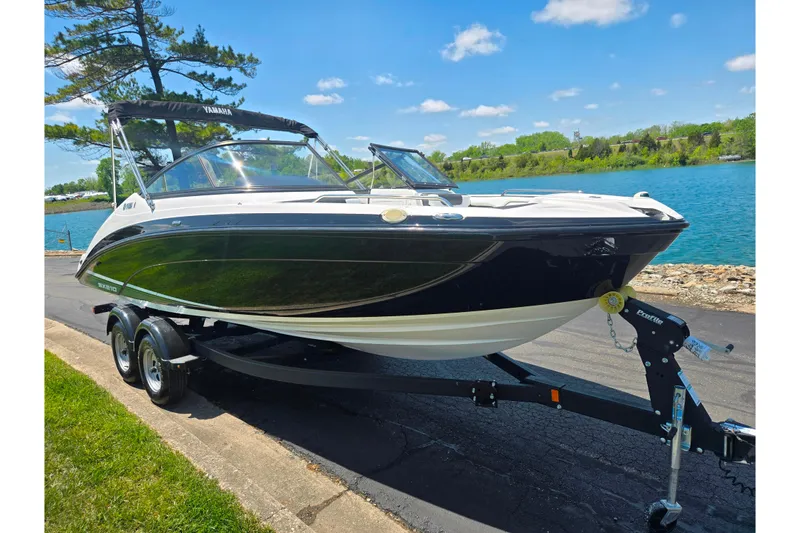 Slide: The Image of 2019 Yamaha Boats SX210 on trailer by a scenic lake under a clear blue sky. - 8
