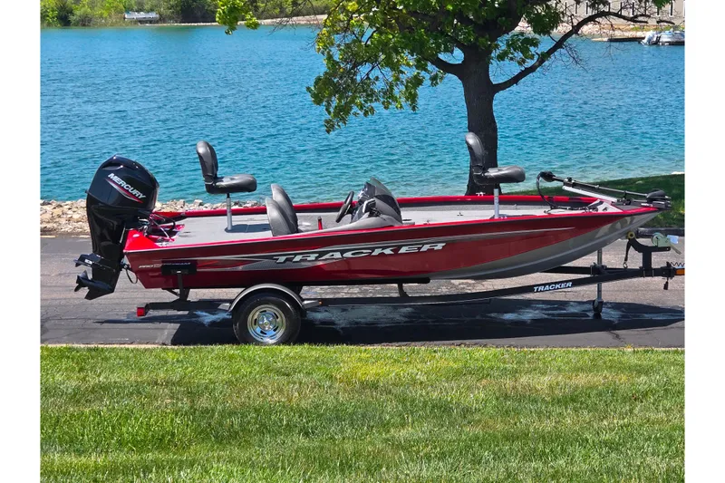 The Image of 2019 Tracker Pro Team 175 TXW boat by a lake, on a trailer. - 0