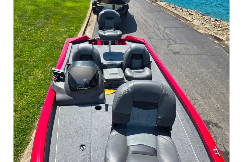 Slide: The Image of 2019 Tracker Pro Team 175 TXW boat with gray seating, parked near water. - 18
