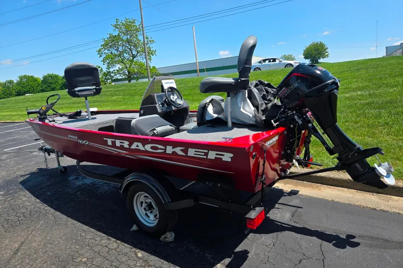 Slide: The Image of 2020 Tracker Pro 160 boat in a parking lot, featuring a red exterior and outboard motor. - 3