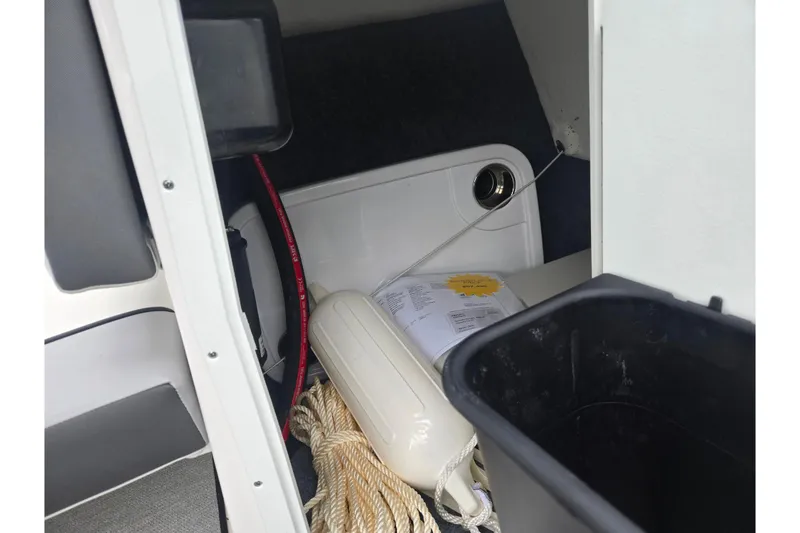 Slide: The Image of Storage compartment of 2024 Yamaha Boats AR220 with rope and fender. - 12
