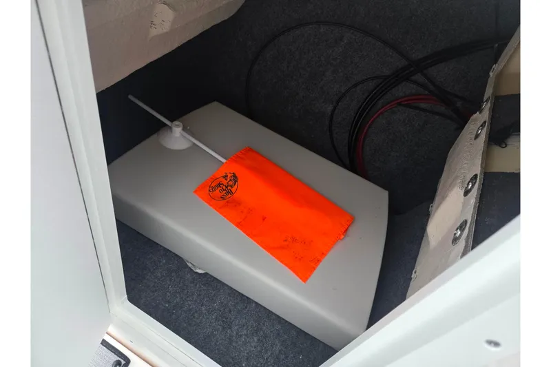 Slide: The Image of 2024 Yamaha Boats AR220 storage compartment with safety equipment and wiring. - 13