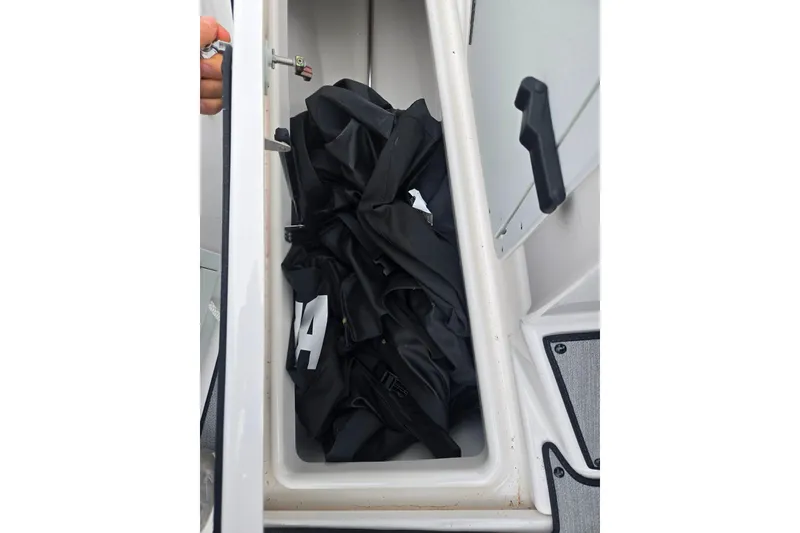 Slide: The Image of Storage compartment in 2024 Yamaha Boats AR220, containing folded black cover. - 14