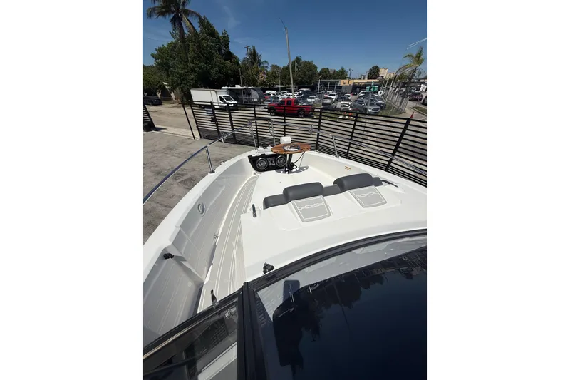 Slide: The Image of Granfort 300 GTX 2026 boat deck with seating and table, parked outdoors. - 12