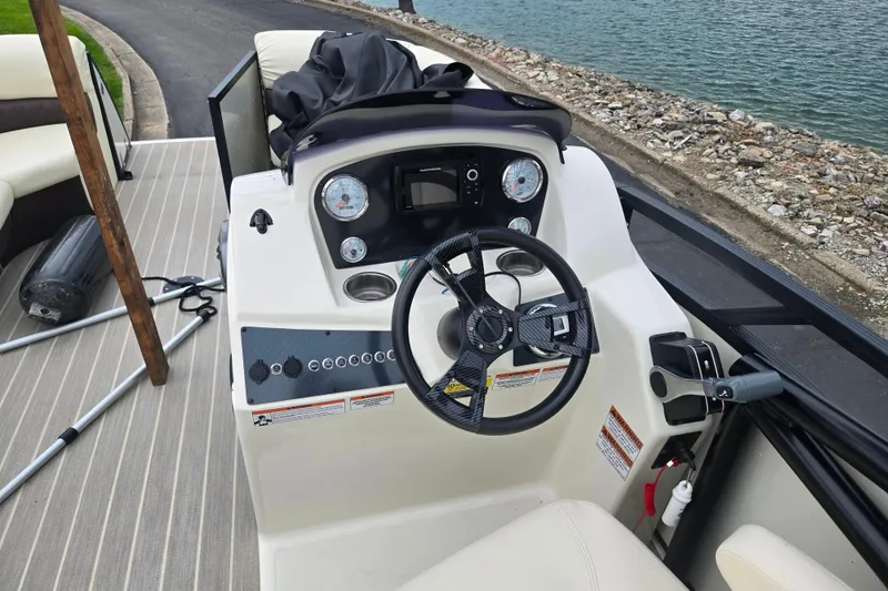 Slide: The Image of 2022 Lexington 621TT Extreme boat dashboard with steering wheel and controls by the water. - 12