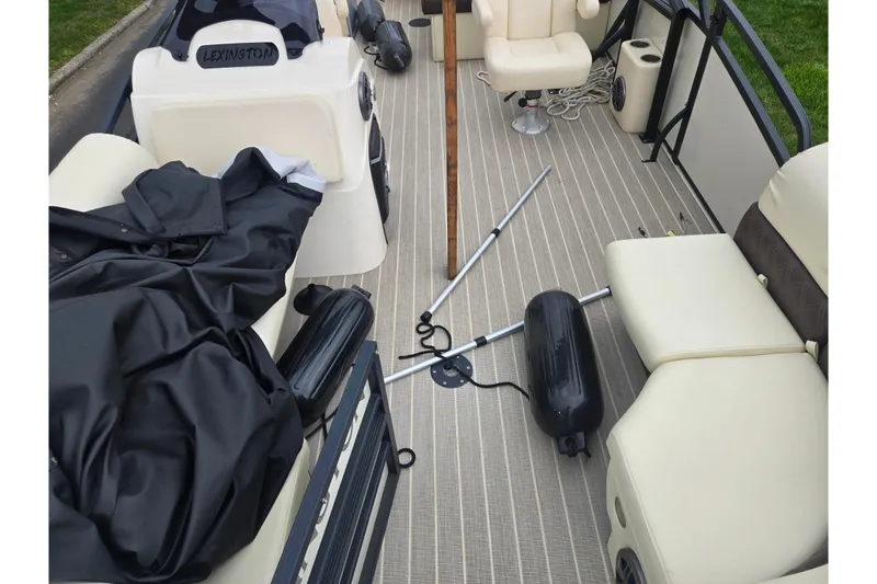 Slide: The Image of 2022 Lexington 621TT Extreme boat interior with beige seating and boating equipment. - 16