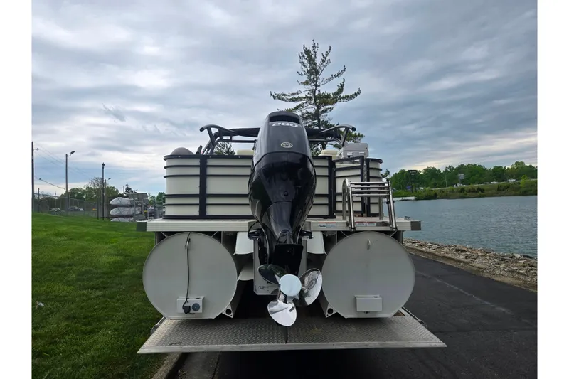 Slide: The Image of 2022 Lexington 621TT Extreme pontoon boat with powerful outboard motor by a scenic lake. - 2