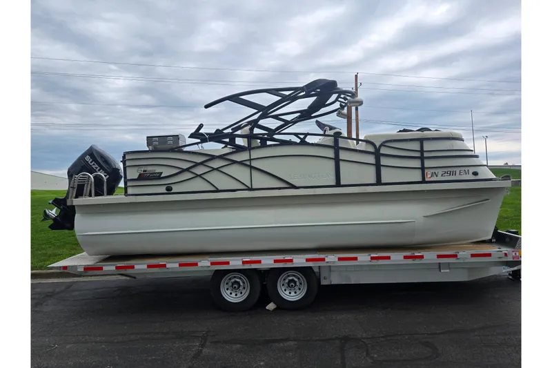 Slide: The Image of 2022 Lexington 621TT Extreme pontoon boat on trailer, featuring Suzuki outboard motor. - 4